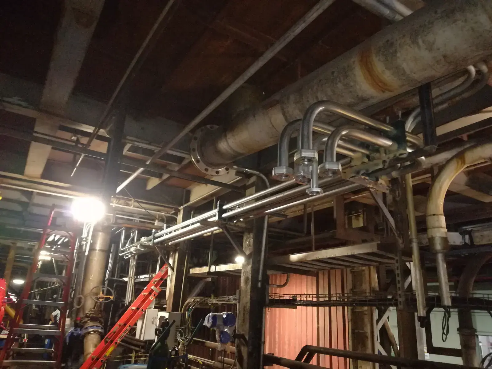 Stainless steel hydraulic lines with flanged connections routed along the milling line